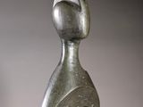 an abstract sculpture of a woman ' s head on a wooden base
