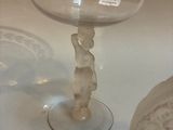 a glass table with a glass bowl on it and a glass vase on the table
