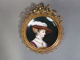 une photo d'une femme coiffée d'un chapeau, accrochée au mur