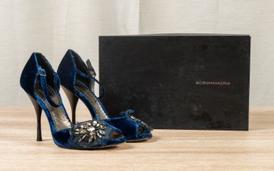 blue high heel shoes and a black box on a wooden table