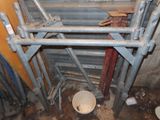 a toilet in the corner of a room with pipes and a bucket
