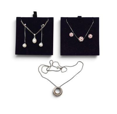 deux colliers et une paire de boucles d'oreilles sur fond blanc
