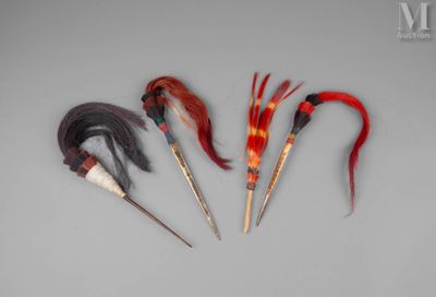 trois plumes de couleurs différentes sont disposées en ligne sur une surface grise
