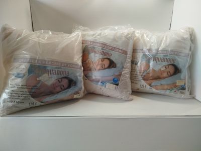 three pillows that are sitting on top of a shelf