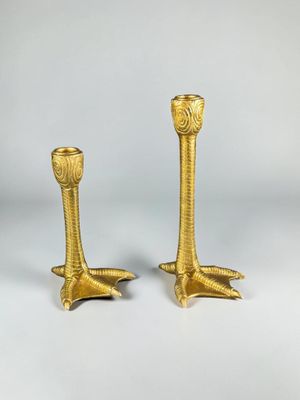 a pair of gold candlesticks on a white background
