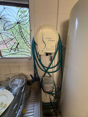 une photo d'une cuisine avec un chauffe-eau et de la vaisselle sur le plan de travail