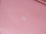 a pink purse sitting on top of a wooden table