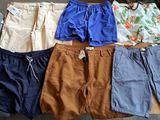 Plusieurs paires de shorts pour hommes sont disposées sur une table