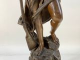 bronze statue of a woman holding a harp and a bow