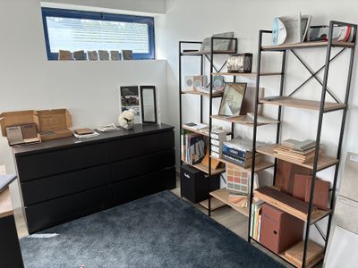 une pièce équipée d'un bureau, d'étagères et d'une commode