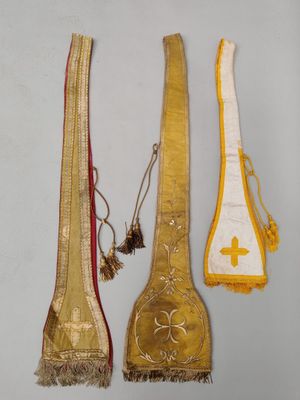 trois morceaux de tissu doré et blanc ornés d'une croix