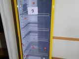 a yellow refrigerator that has a sign on the door