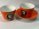 deux tasses et soucoupes avec l'image d'une femme et d'un homme dessus