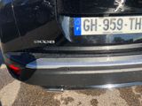 the rear end of a black car with a license plate on it