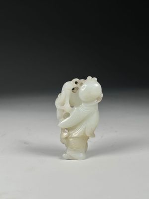 a white jade figurine of a bear holding a baby
