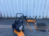 an image of a lawn sweeper on the ground in front of a building