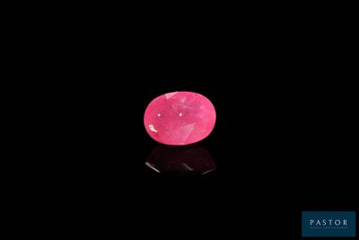 un diamant rose sur une surface noire, avec un reflet