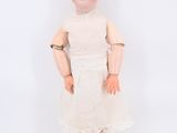 an image of a doll with a bald head and a white dress
