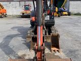 a small excavator that is sitting in a parking lot