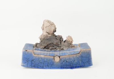 a small blue box with a statue on top of it