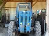 un tracteur bleu garé à l'intérieur d'un bâtiment