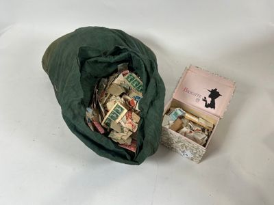 un sac rempli d'argent posé à côté d'une boîte remplie d'argent
