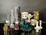 de nombreux vases en verre et autres objets en verre posés sur une table