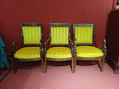 trois chaises aux assises rembourrées de jaune dans une pièce
