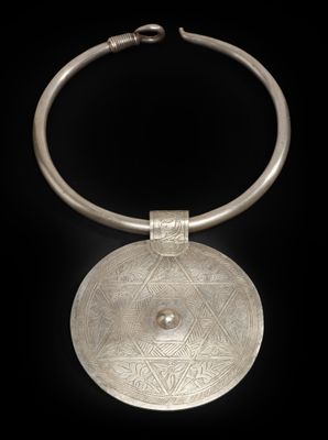 un gros plan d'un collier en argent sur fond noir