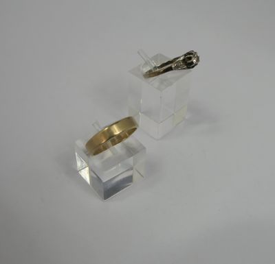 pair of gold and silver rings on clear acrylic stand