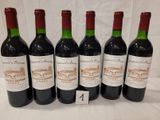six bottles of wine are lined up on a table