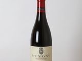 a bottle of red wine sitting on a wooden table