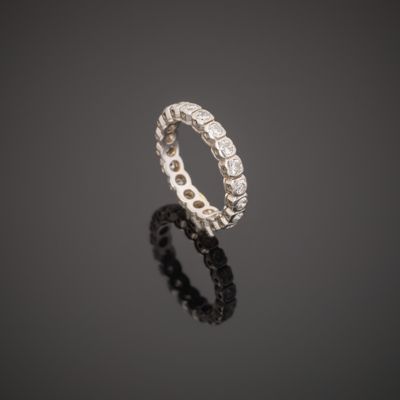 une bague en or blanc et diamants posée sur une surface réfléchissante