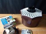 a brown and white fan on a wooden table next to other items