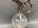 un pichet ancien en verre plaqué argent, muni d'une anse incurvée