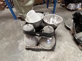 many bowls and pans sitting on the floor in a warehouse