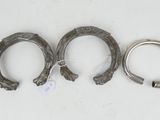 three silver horseshoes with tags on them sitting on a white surface