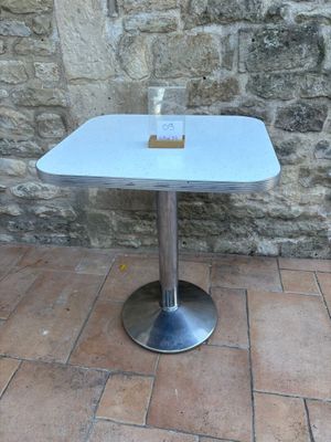 a glass of water sitting on a table in front of a stone wall