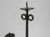 two candles that are sitting on a metal stand