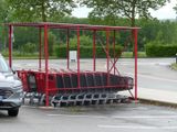 cars parked in a parking lot with a shopping cart in the middle of the parking lot