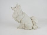 a figurine of a white dog sitting on a white surface