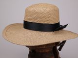 une image représentant un chapeau de paille orné d'un ruban noir