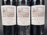 three bottles of red wine are lined up on a table