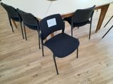a white table with four black chairs around it