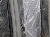 de nombreux matelas emballés dans du plastique dans un entrepôt