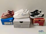 three pairs of shoes are sitting on top of boxes on a table
