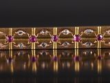 un gros plan d'un bracelet plaqué or orné de pierres roses