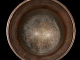 a close up of a metal bowl on a black background