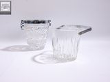 un pichet en verre et un verre posés sur une table blanche