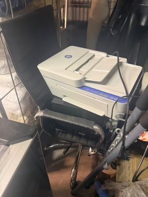 une photo d'une imprimante posée sur une chaise dans une pièce